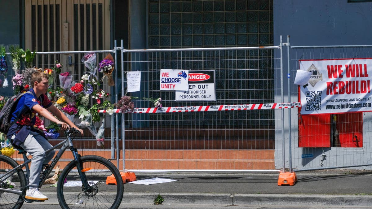 Radfahrer fährt an Synagoge vorbei