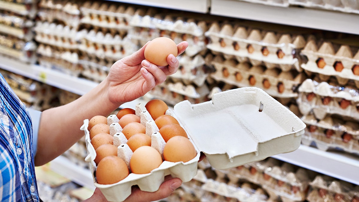 Uma mulher de empacotamento de ovos no supermercado