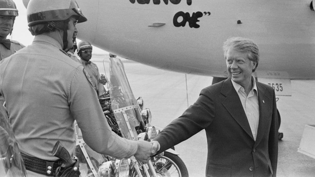 jimmy carter shaking hand flight passenger