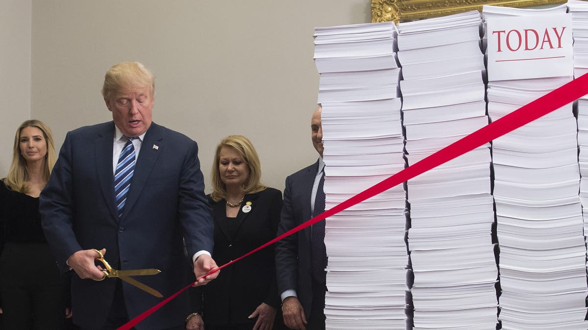 President Trump holds gold scissors to symbolically cut government red tape during an event at the White House on Dec. 14, 2017. (Saul Loeb/AFP via Getty Images)