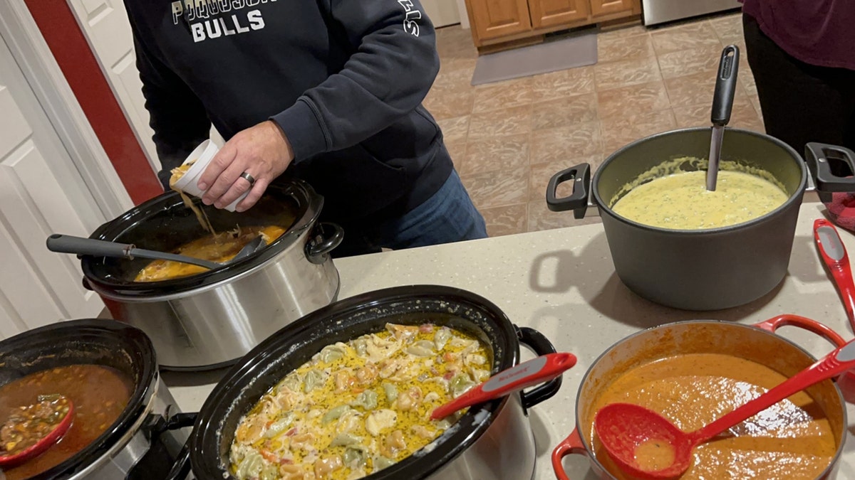 Rob Shepherd hosts a holiday soup potluck party with his church group with five options: tomato, vegetable, broccoli cheese, sausage dumplings and chicken tortillas.