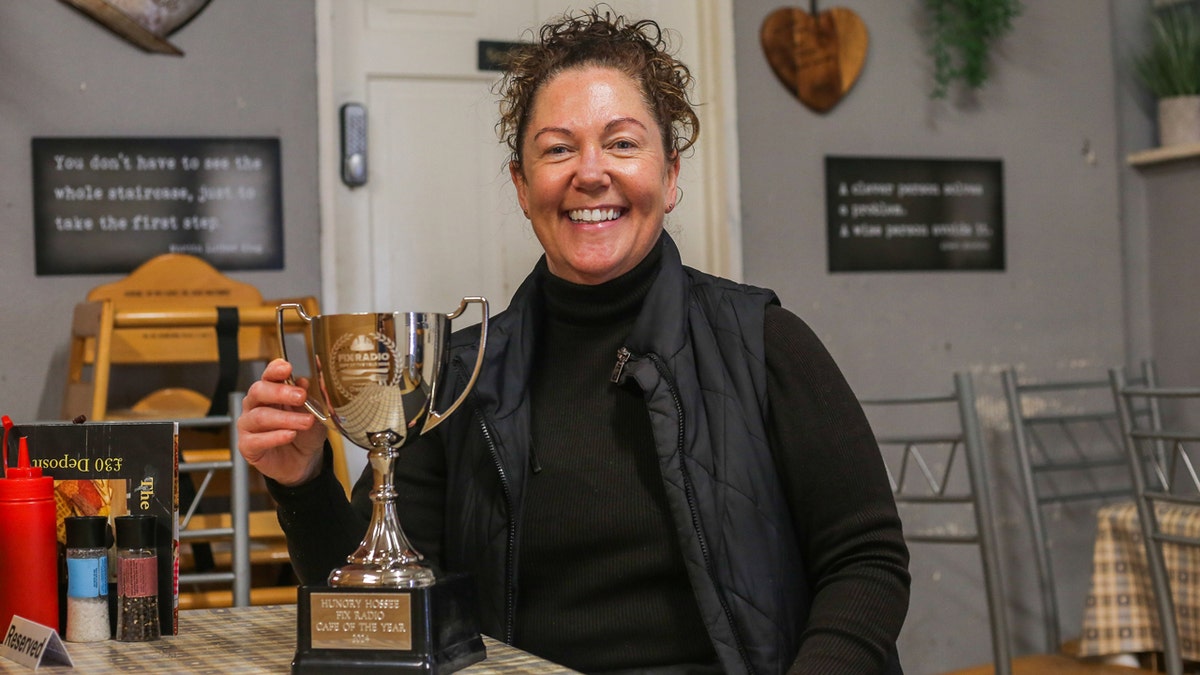 La propietaria de Hungry Hossee, Shelaine Crabtree, posa con su trofeo a la cafetería del año.