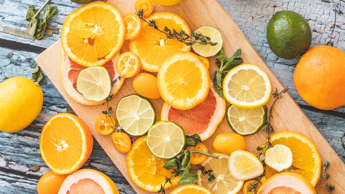 Slices of fresh citrus fruit on wooden cutting board