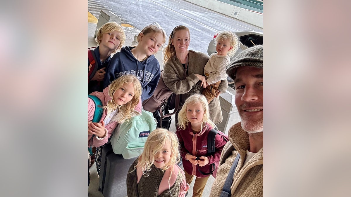 James Van Der Beek, wearing a fuzzy jacket, takes a selfie with his wife Kimberly and their six children