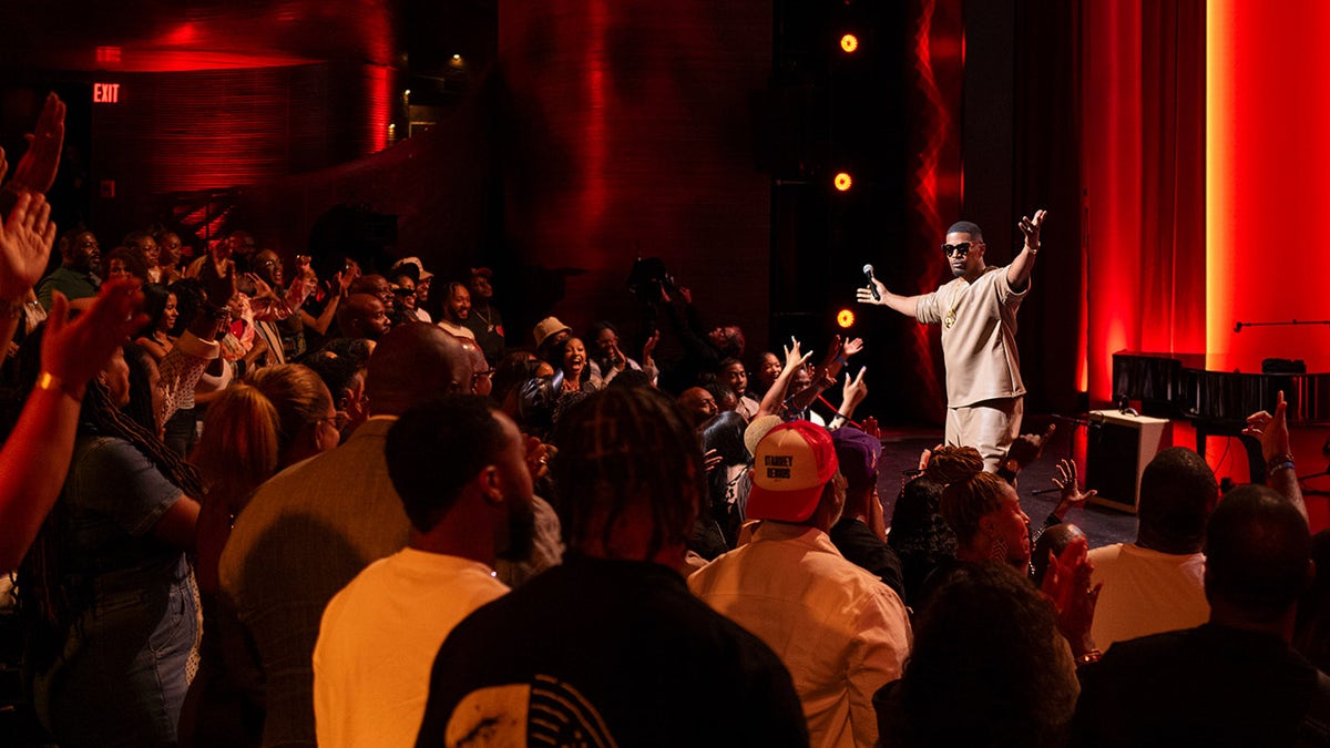 Jamie Foxx holds his hands in the air at Atlanta clubhouse.