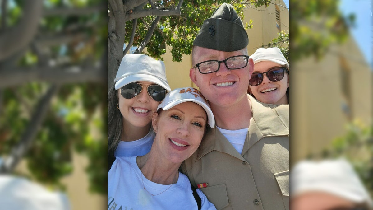 Jennifer Box stands with three adult children outside