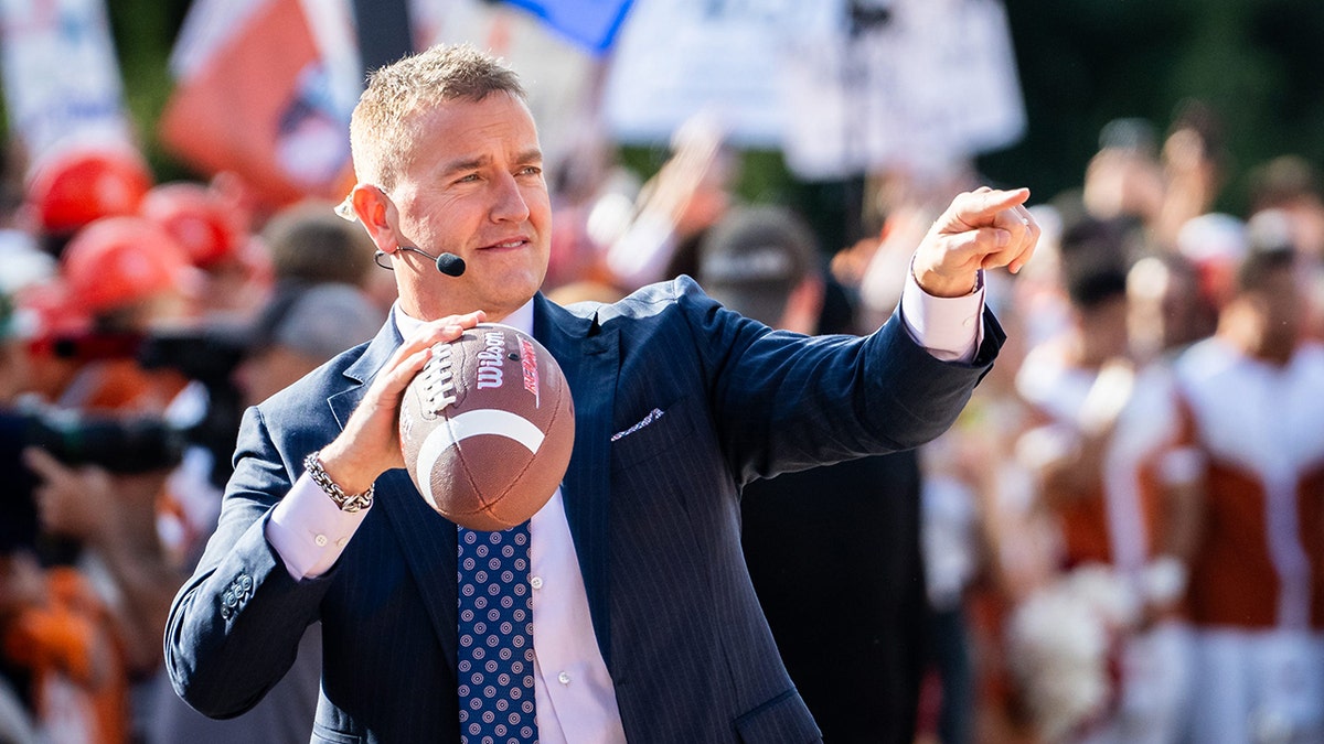 Analyst Kirk Herbstreit tosses the football with fans on the set of ESPN's College Game Day at the University of Texas ahead of the Longhorns' game against the Georgia Bulldogs in Austin, Texas, on Oct. 19, 2024.