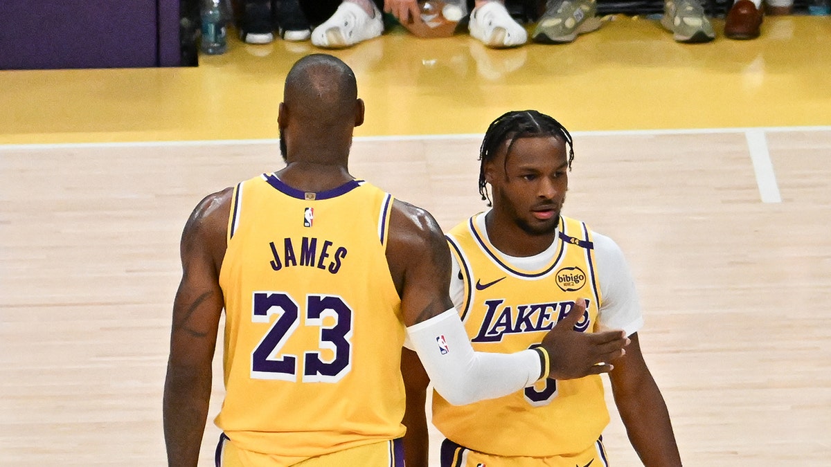 LeBron James, #23, and Bronny James, #9 of the Los Angeles Lakers, on the court for the first time during the game against the Minnesota Timberwolves at Crypto.com Arena on Oct. 22, 2024 in Los Angeles.