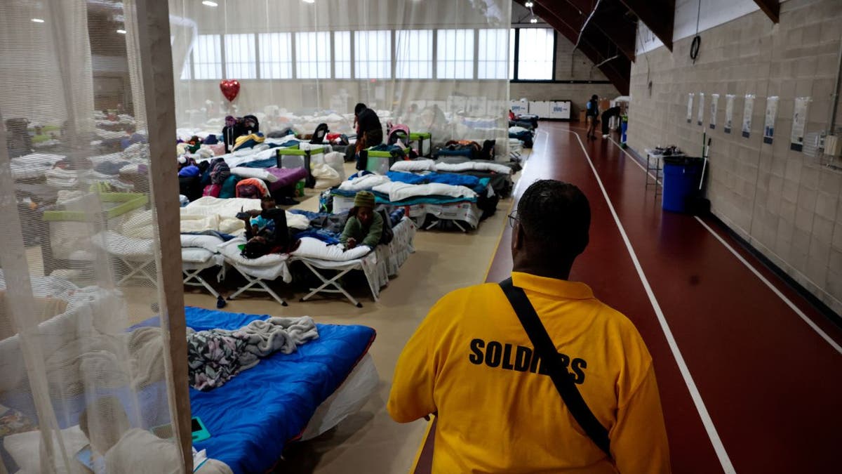 Meshach Little of Northill Wilkston Security Firm travels the perimeter of the main life area in the new emergency overflow refuge for migrants from the Melnea A. Cass recreational complex. (Photo by Craig F. Walker / The Boston Globe via Getty Images)