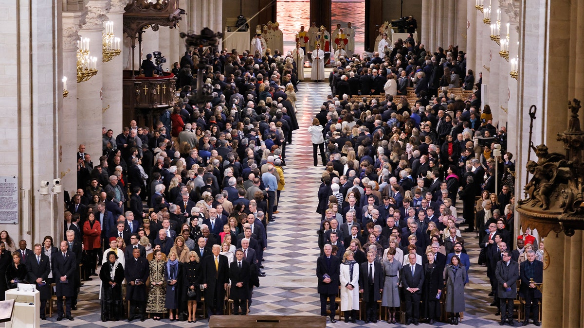 Guests stand as the doors to Notre Dame Cathedral open during a ceremony to mark the reopening of the landmark cathedral in central Paris, December 7, 2024. 