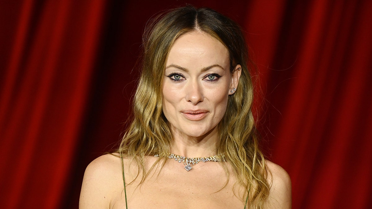 Olivia Wilde purses her lips on the carpet