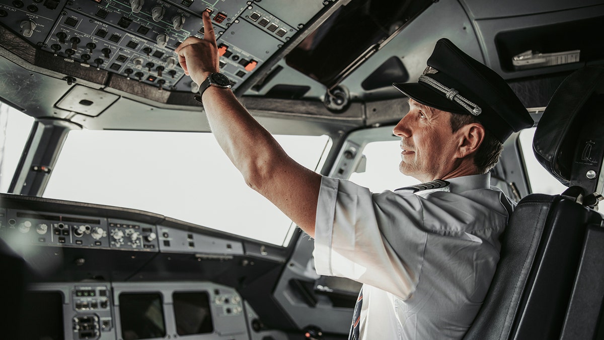 pilot flipping switch in cockpit