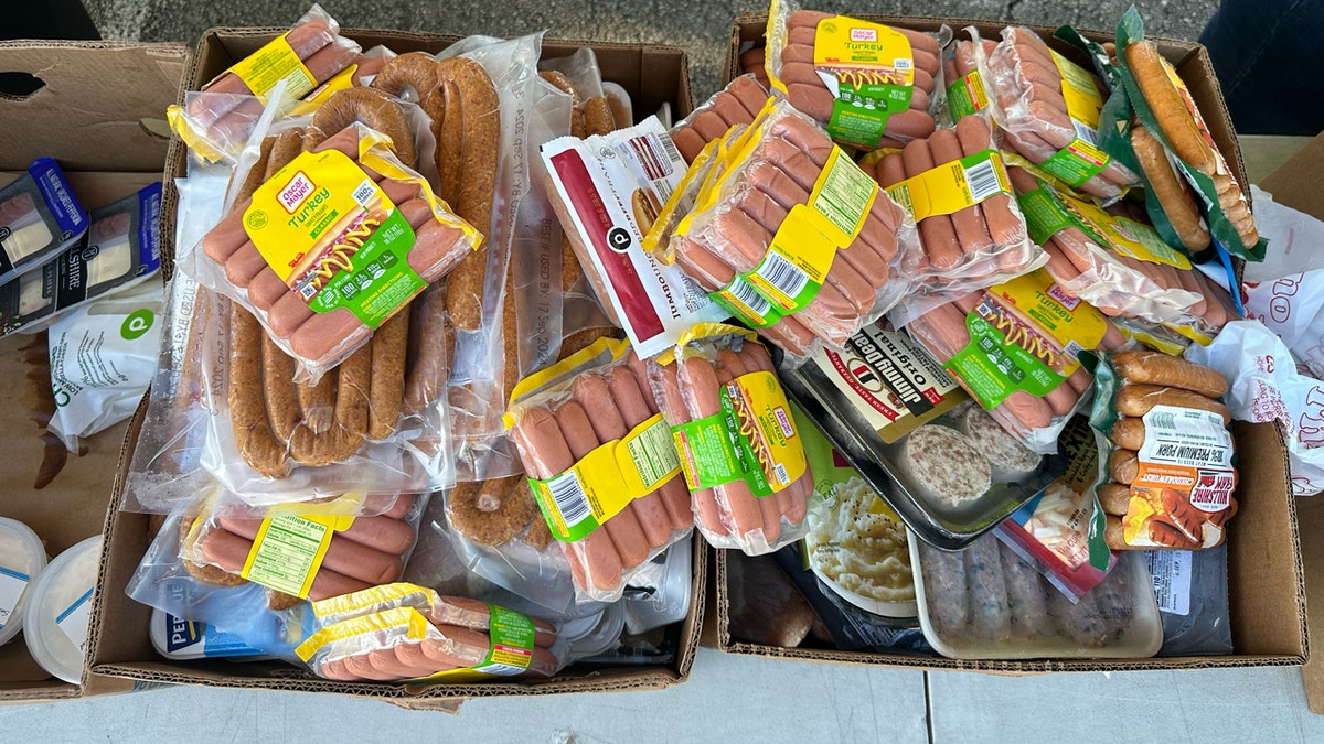 Hot dogs and sausages sit on the table at the Place of Hope food distribution.