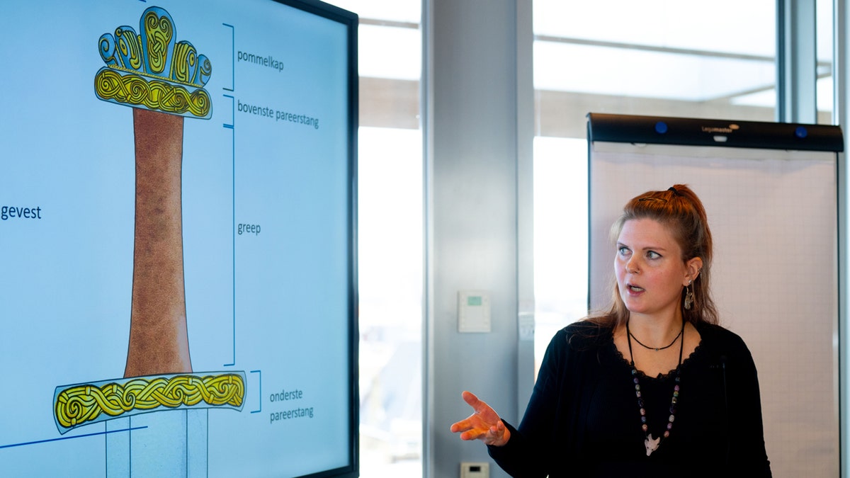 A woman presents about an ancient find found in the Netherlands