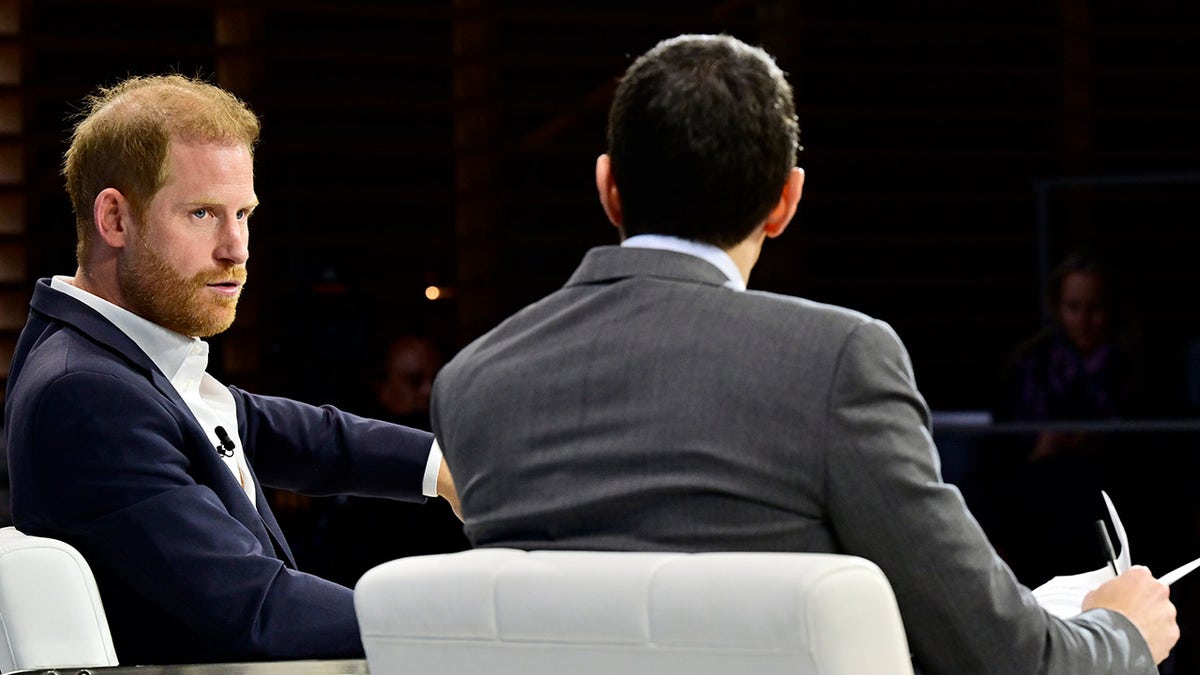 Prince Harry wears a blue suit during a panel discussion