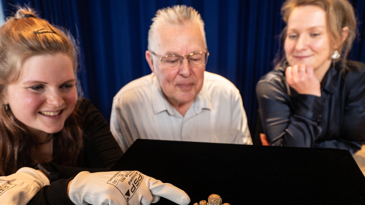 The finder of an ancient Viking weapons fragment examining his find