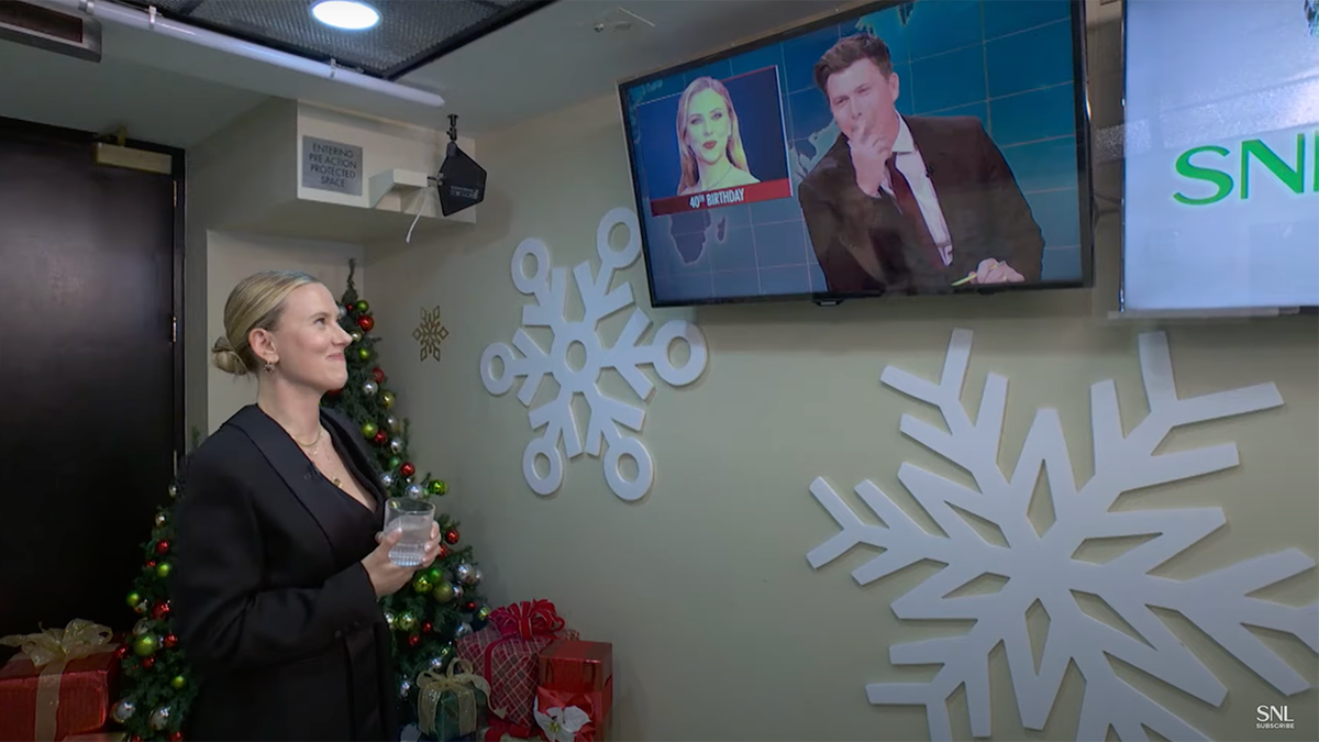 Scarlett Johansson looks up at the TV screen backstage at 