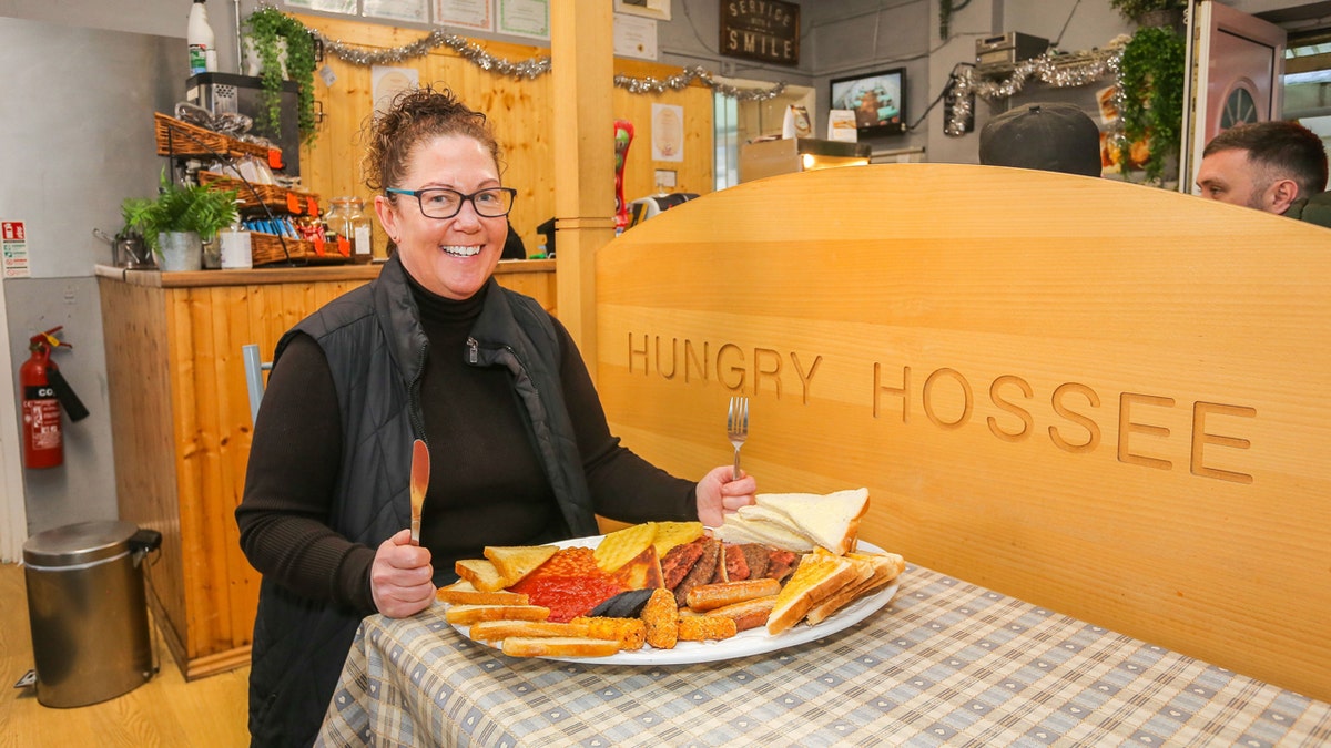 Shelaine Crabtree, propietaria de Hungry Hossee, posa con el plato de desayuno "Big One".