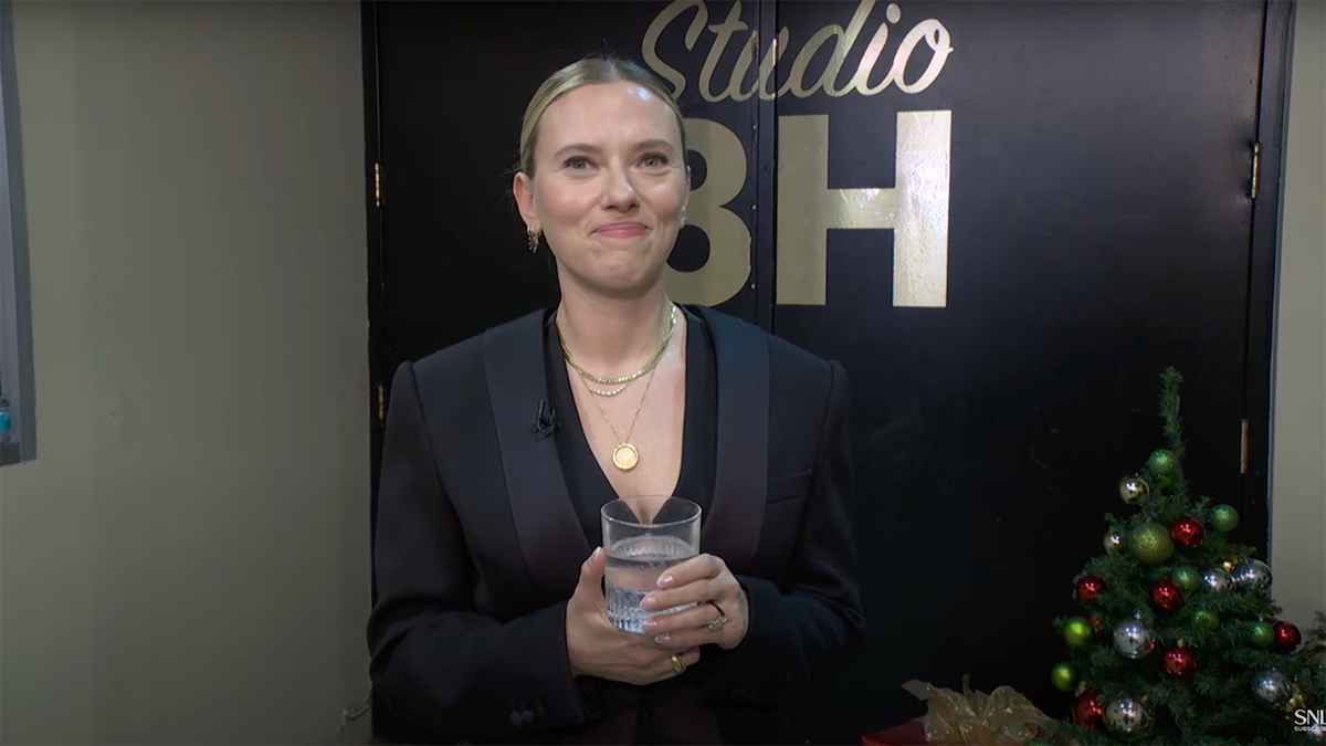 Scarlett Johansson clutches her drink and stares at the camera backstage. "saturday night live"