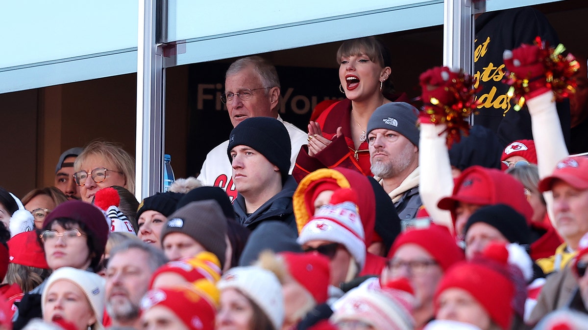 Taylor Swift cheers animatedly for the Chiefs as she sits beside her father Scott Swift, who is seated next to Donna Kelce in a box