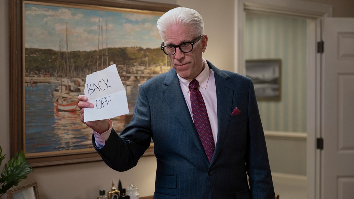 Ted Danson holding up a note in a scene from "A Man on the Inside"