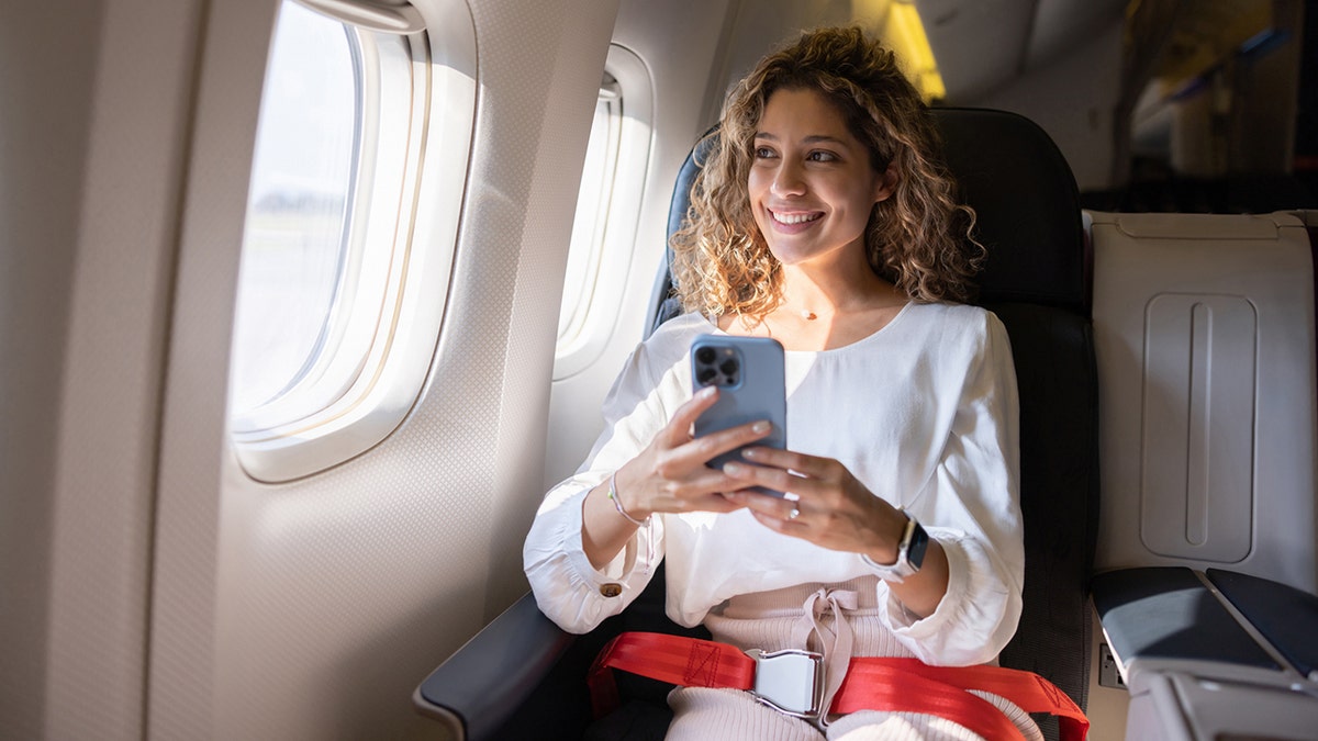 woman on phone aboard airplane