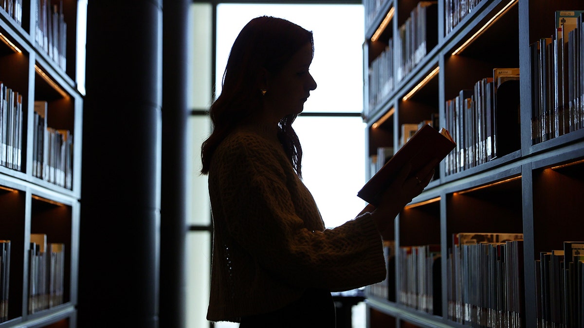 Woman reading a book at a library