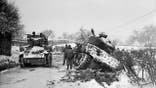 January 1945:  Hard going for US tanks at Amonines, Belgium, on the northern flank of the 'battle of the bulge'. A tank on the road passes another being dug out of the snow.  (Photo by Fred Ramage/Keystone/Getty Images)