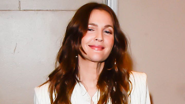 Drew Barrymore kneels before Dylan Mulvaney in interview