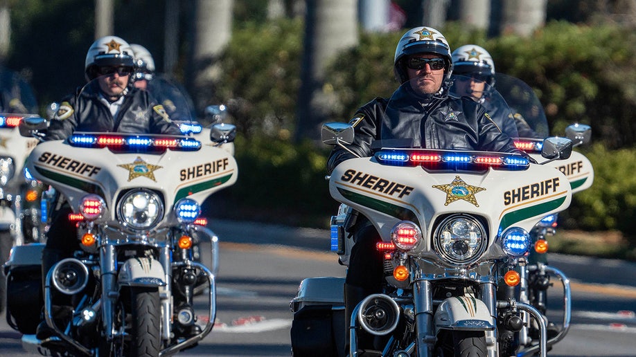 Law enforcement officers ride their motorcycles south along State Road 7 during a procession for three Palm Beach County Sheriff's Office deputies who died last month