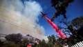 A plane makes a drop as smoke billows from the Palisades Fire at the Mandeville Canyon, in Los Angeles, California, U.S., January 11, 2025. - Fox News