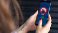 A woman looking at a VPN app on her phone - Fox News