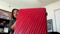 Alison Joyner holds up a red suitcase she used to travel to the Bahamas. - Fox News
