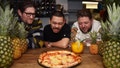 Francis Woolf, Quin Jianoran and Felix Rehberg, co-owners of Lupa Pizza in England, stare at a Hawaiian pizza and its pineapple topping. - Fox News