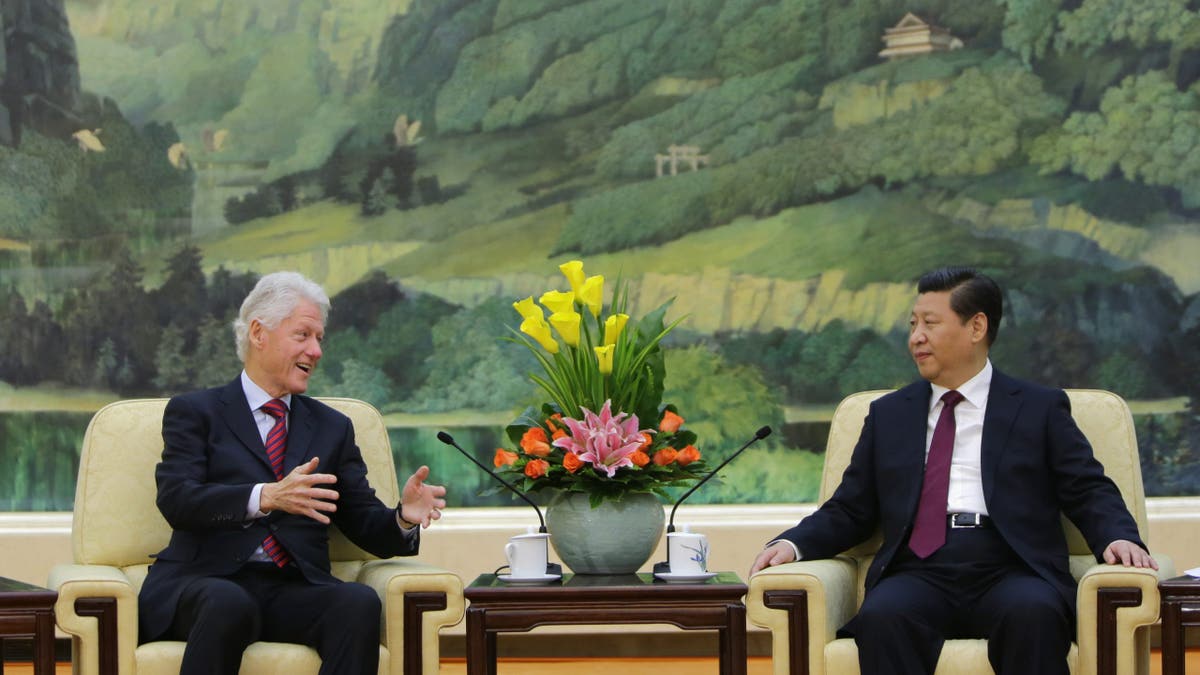 El ex presidente Bill Clinton(izquierda) habla con el presidente chino Xi Jinping en 2013.