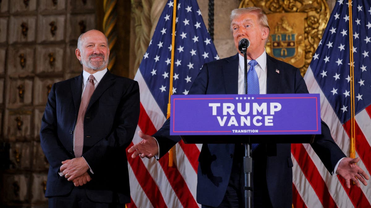 President Trump at lectern, Howard Lutnick to his right