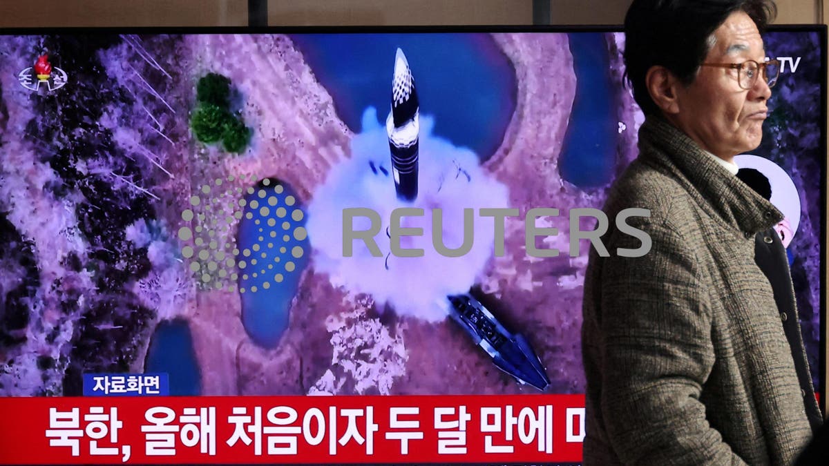 Un hombre pasa junto a un televisor que emite una noticia sobre Corea del Norte disparando un misil balístico hacia el mar frente a su costa oriental, en Seúl, Corea del Sur.