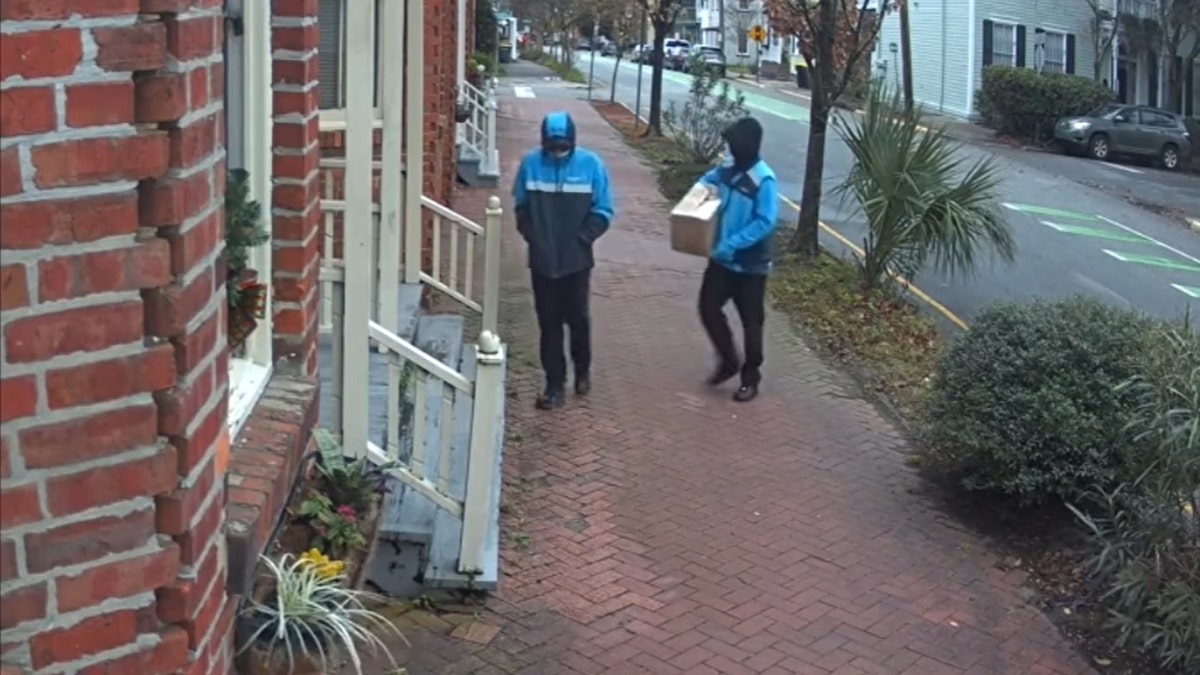 The two men disguised as Amazon workers approach Hardison's door