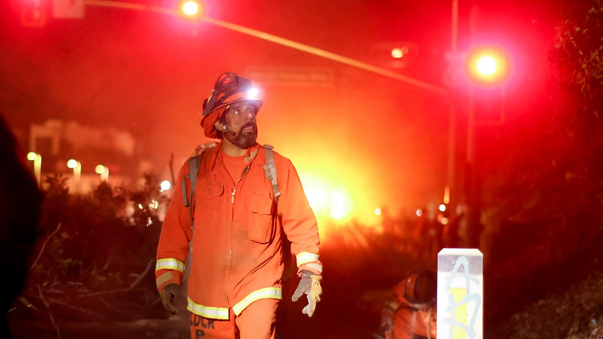 A California Department of Corrections hand crew works containment lines ahead of the Palisades Fire