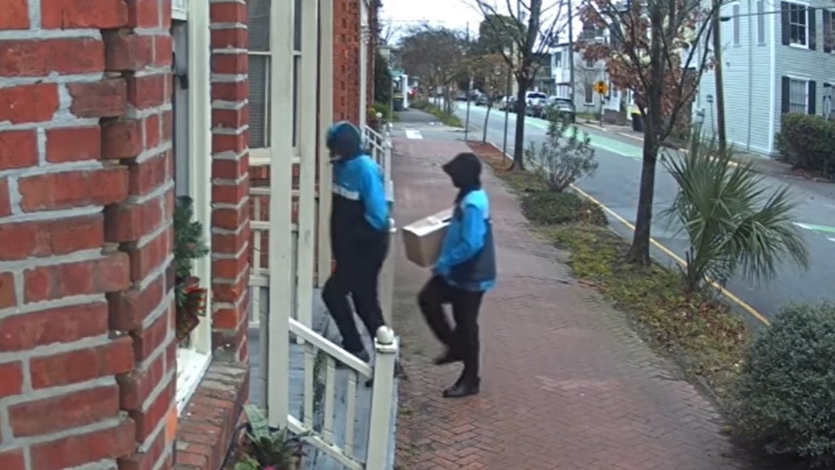 The two men disguised as Amazon workers approach Hardison's door