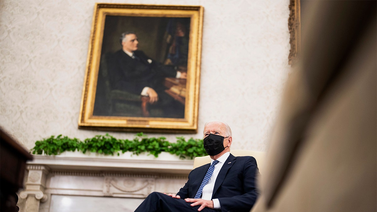 Biden sits with mask on in the Oval Office