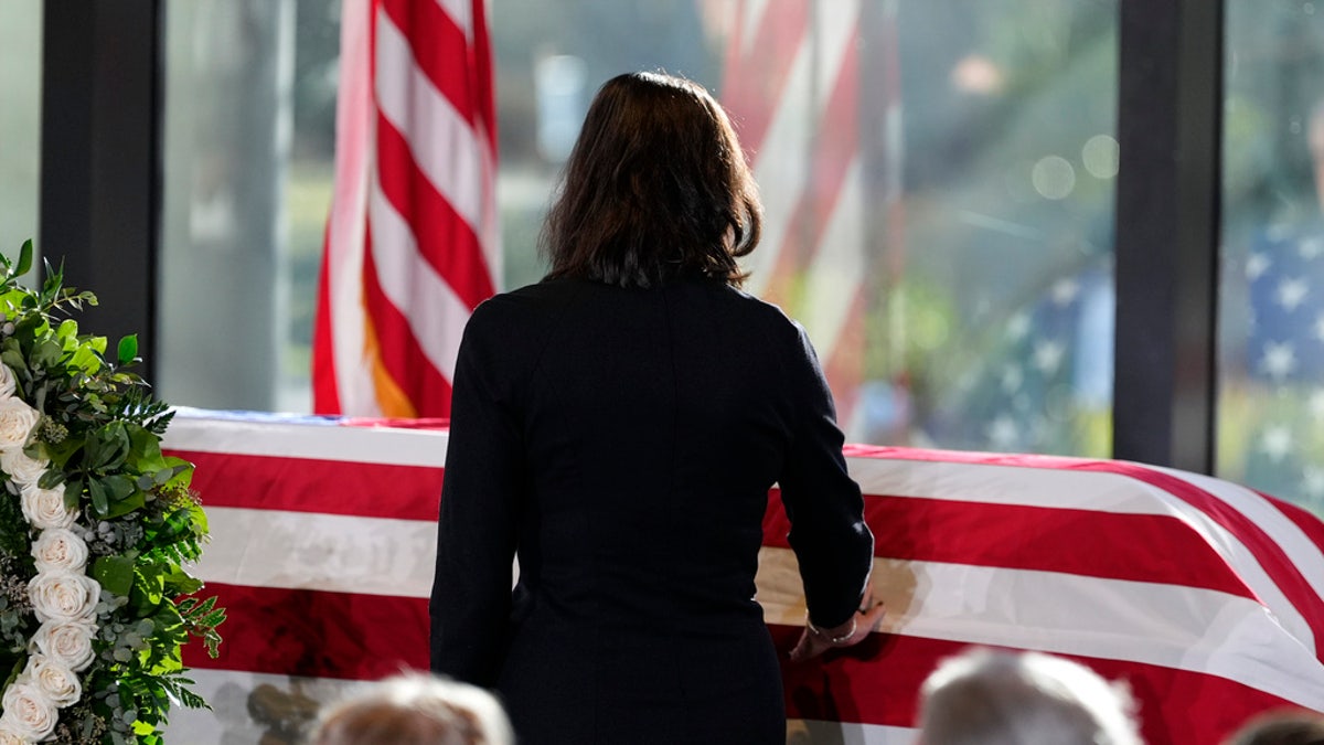 Paige Alexander, CEO of The Carter Center, touches the casket, as Amy Carter and her husband John Joseph "Jay" Kelly, foreground, watch, during a service for former President Jimmy Carter at the Jimmy Carter Presidential Library and Museum in Atlanta, Saturday.