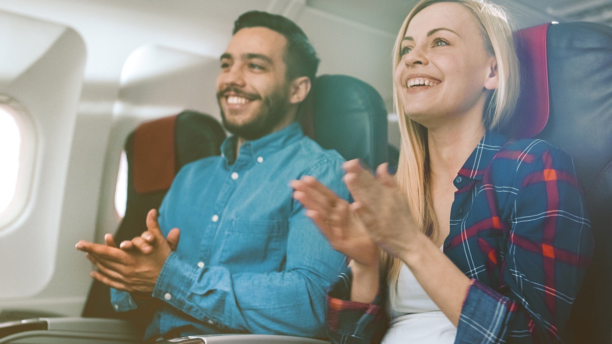 couple clapping on flight after landing