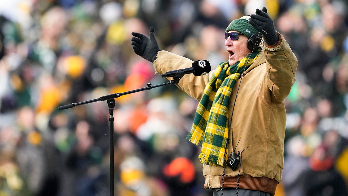 Craig T. Nelson singing the National Anthem in Green Bay Packers' hat and scarf at Lambeau Field