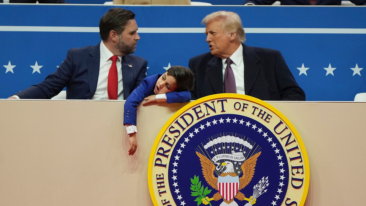 Vice President JD Vance, left, President Donald Trump, right, and Vance's son Vivek attend at an indoor Presidential Inauguration parade