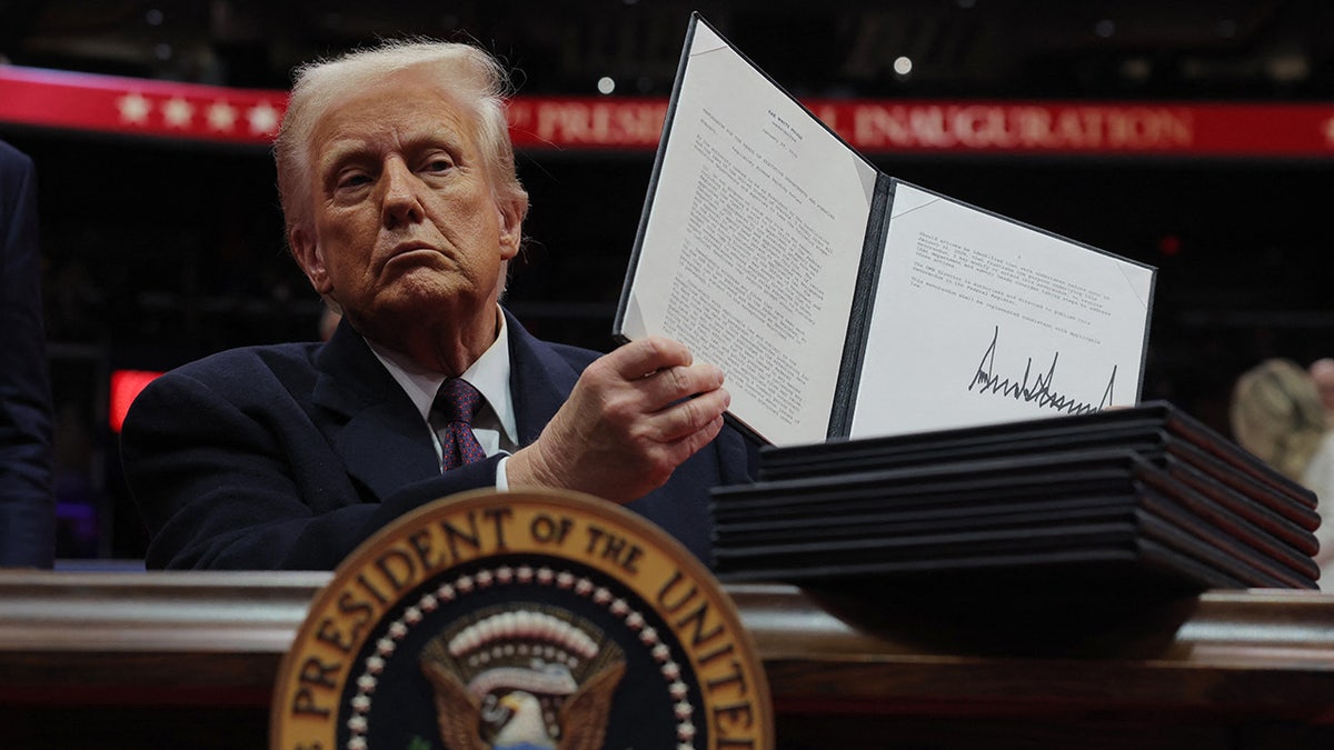 US President Donald Trump shows his signature on an executive order