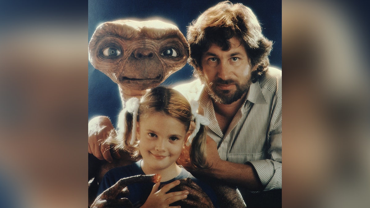 ET with Steve Spielberg in a vertical striped shirt and Barrymore's face with pigtails