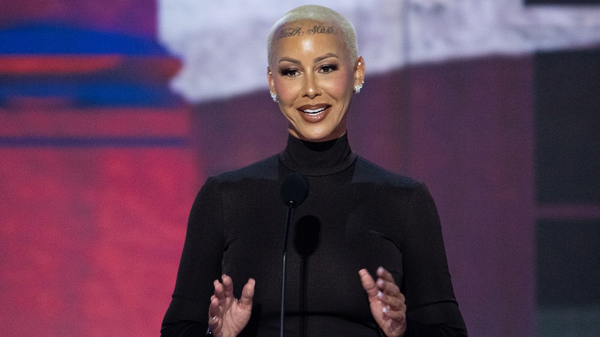 Amber Rose in a black turtleneck stands behind a podium at the Republican National Convention