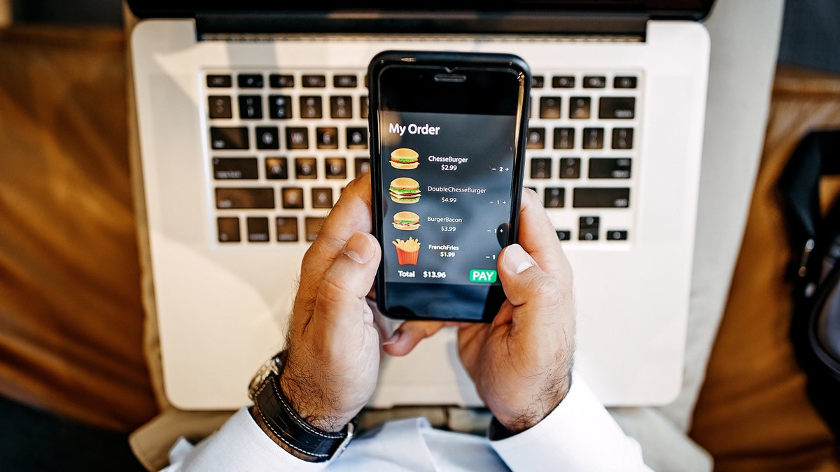 Food prices are seen connected  a man's telephone  app.