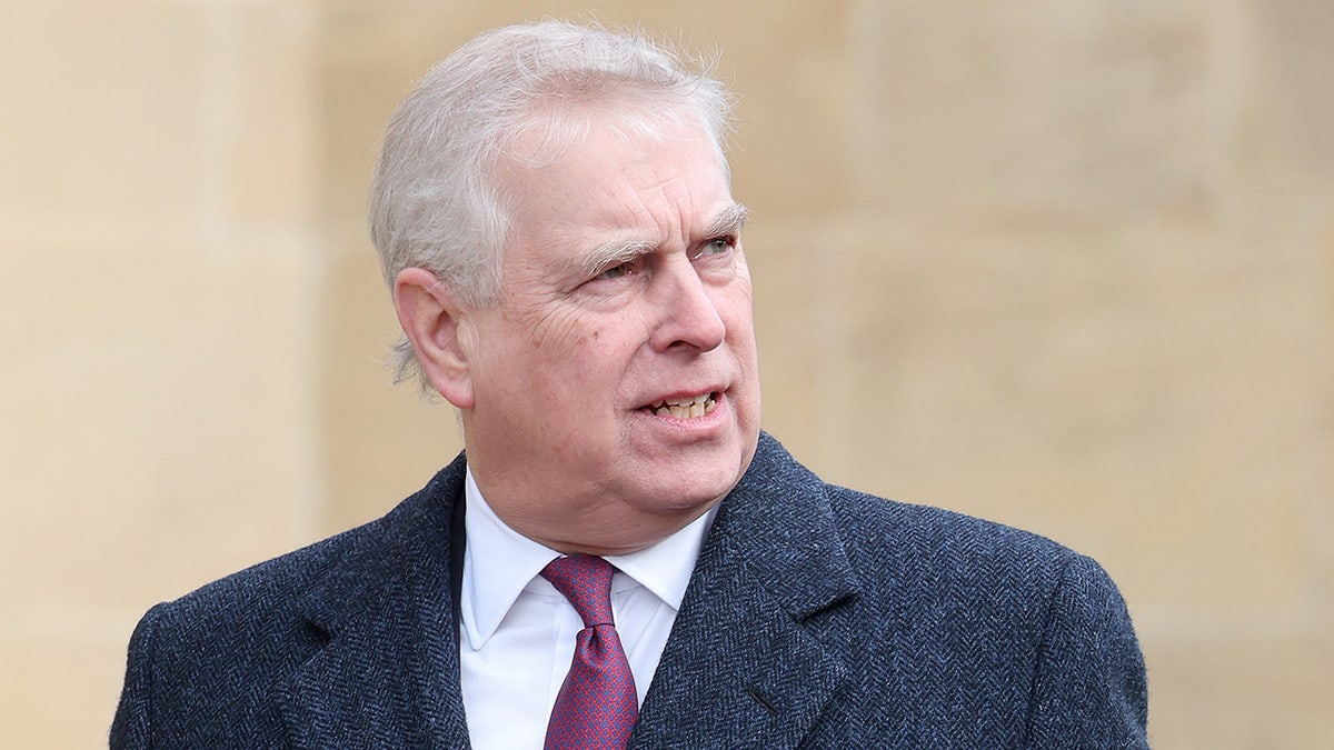 Prince Andrew looks far in a gray jacket, a white shirt and a Burgundy tie.